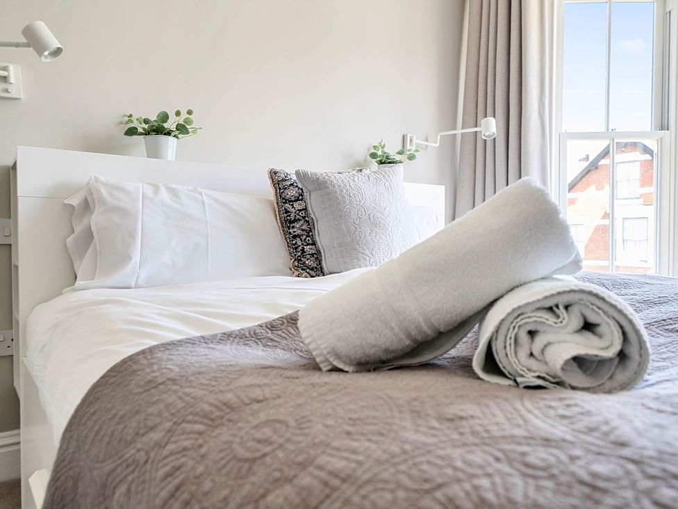 A bedroom with a bed and two towels at Victorian Beach House in Saltburn-By-The-Sea