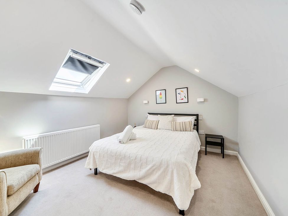 A bedroom with a bed and chair at Victorian Beach House in Saltburn-By-The-Sea