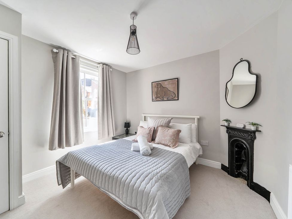 A bedroom with a bed and a fireplace at Victorian Beach House in Saltburn-By-The-Sea