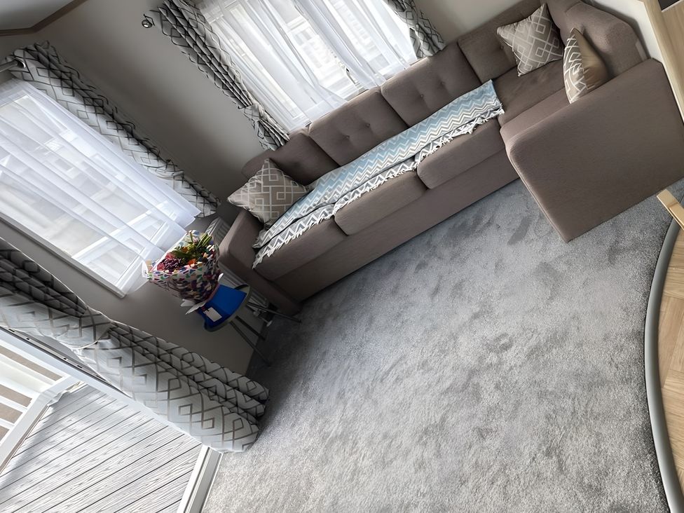 A living room with a sofa and flower arrangement at Pine 48