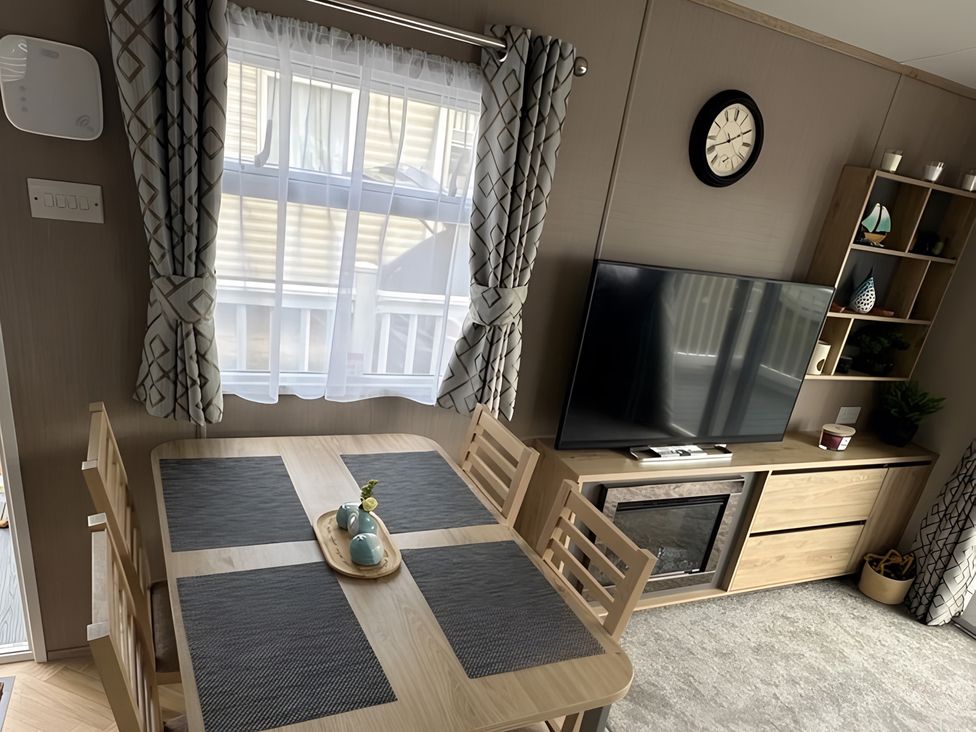 A dining room with a table and television at Pine 48