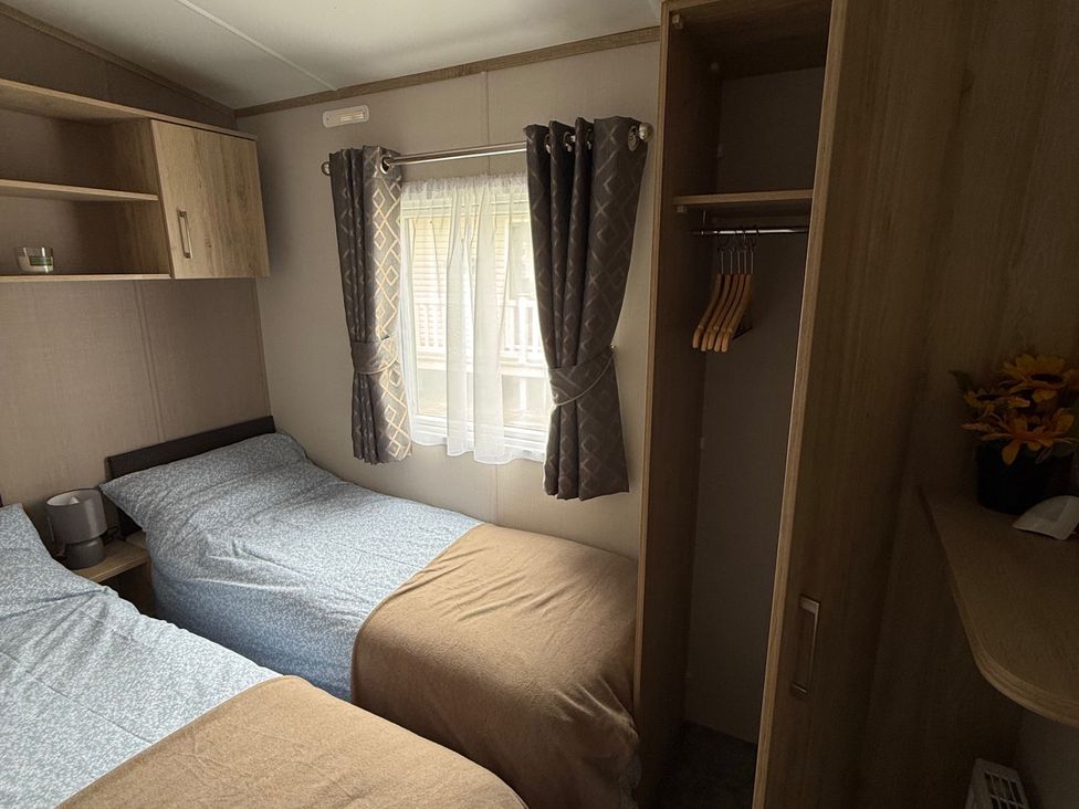 A bedroom with two beds and a wardrobe at Pine 48