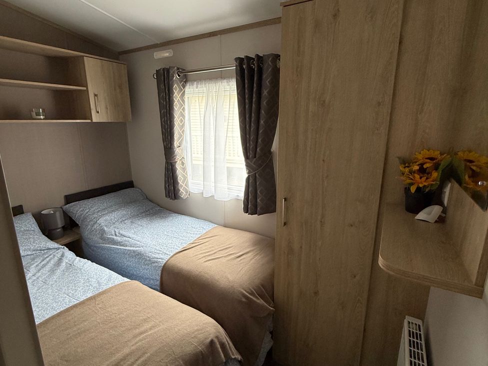 A bedroom with two beds and a wardrobe at Pine 48