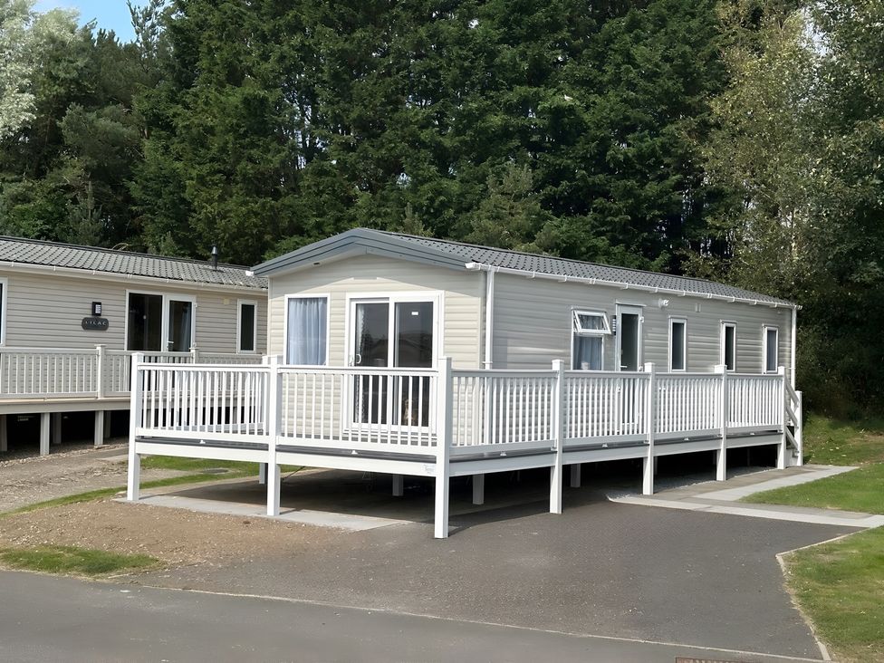 A mobile home with a deck and windows at Pine 48