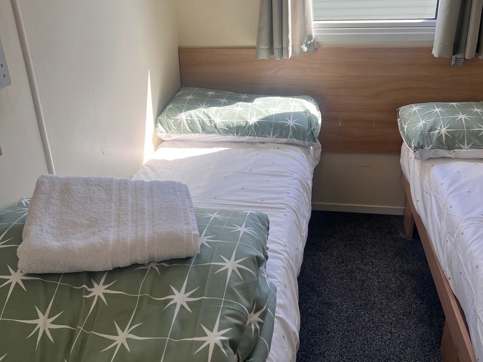 A bedroom with two twin beds and a towel at 214 Oaklands Area