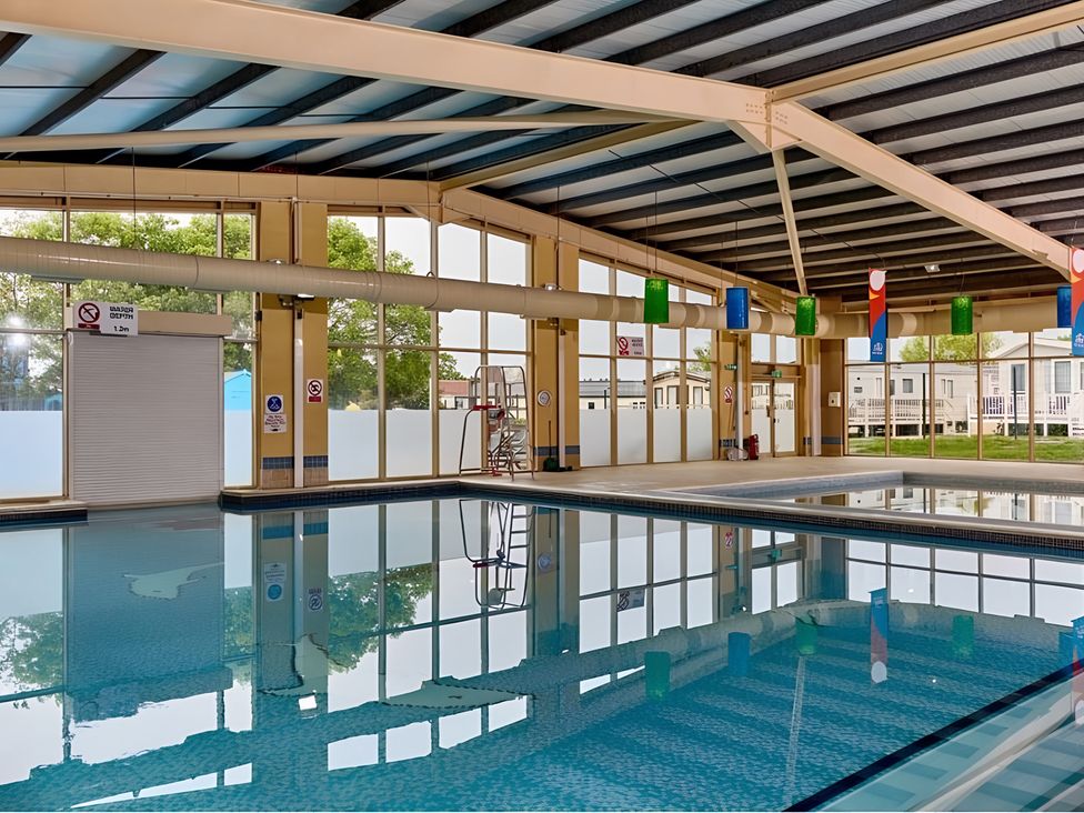 An indoor pool area with a swimming pool and lifeguard chair at 214 Oaklands Area