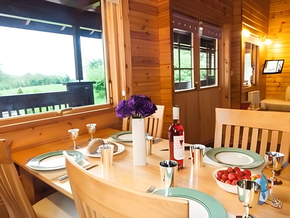 A dining room with a table set for a meal at Gisburn Forest Lodge