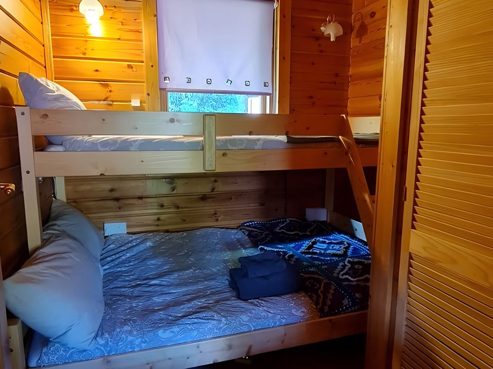 A bedroom with a bunk bed and blankets at Gisburn Forest Lodge