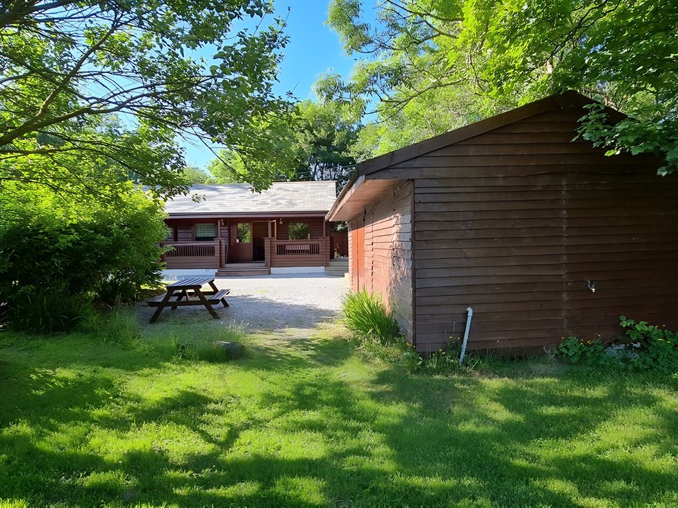 An outdoor area with a cabin and shed at Gisburn Forest Lodge