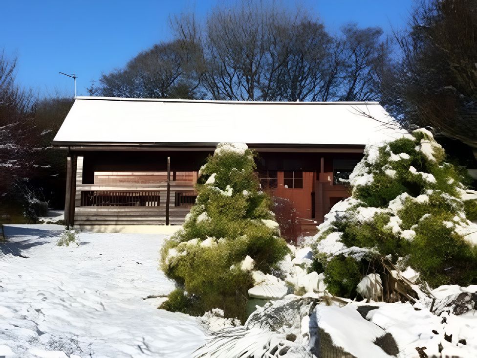 An outdoor view of a house covered in snow at Gisburn Forest Lodge