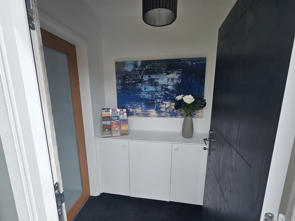 An entrance with a cabinet, vase with flowers, and wall art at 58 Clifton Rise
