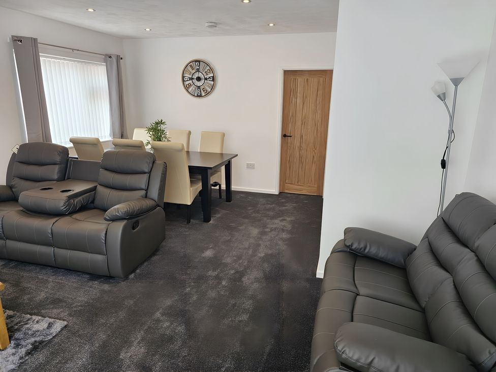 A living room with recliners and a dining table at 58 Clifton Rise
