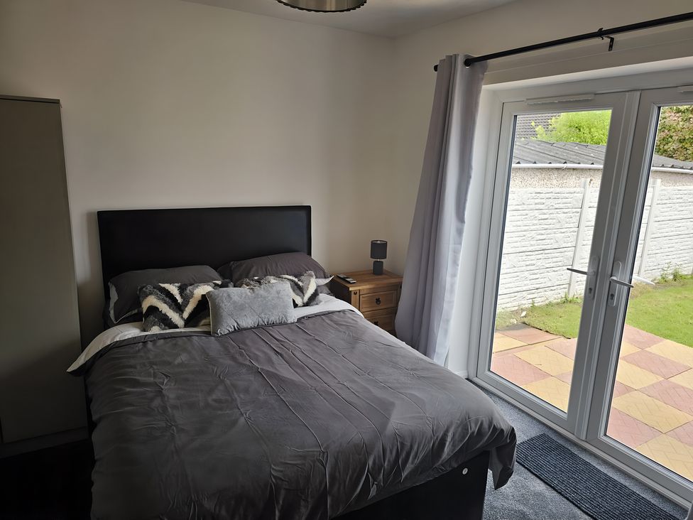 A bedroom with a bed and sliding doors at 58 Clifton Rise