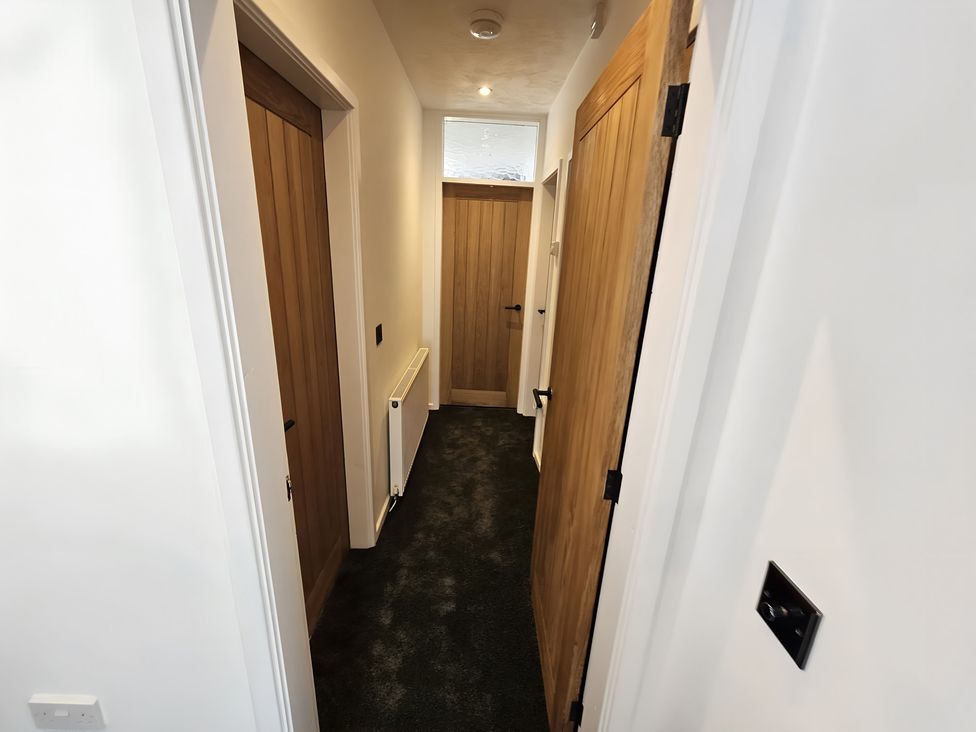 A hallway with wooden doors and radiator at 58 Clifton Rise