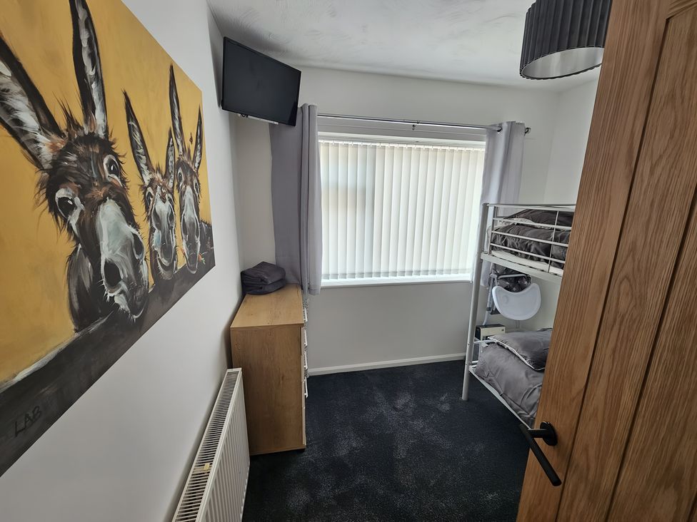 A bedroom with a bunk bed and television at 58 Clifton Rise