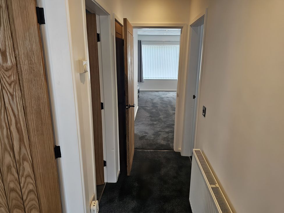 A hallway with doors and a window at 58 Clifton Rise
