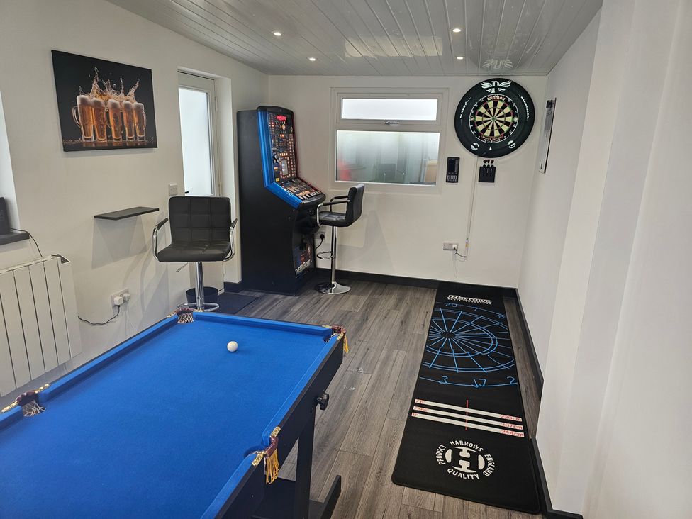 A snug room with a pool table and gaming machine at 58 Clifton Rise