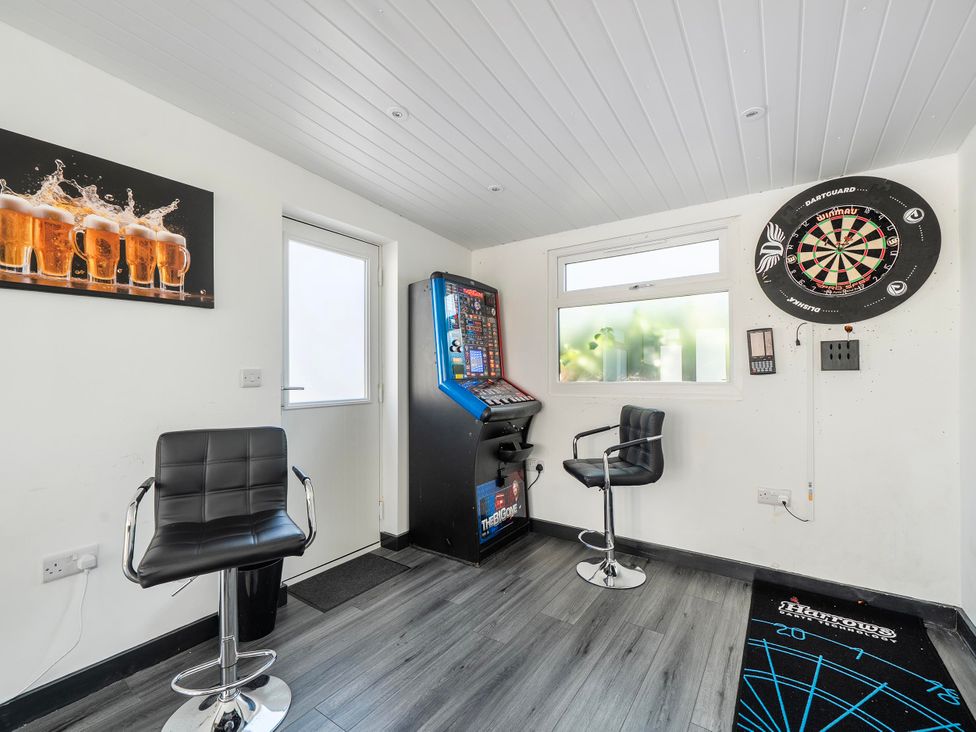 A snug with gaming machine and dartboard at 58 Clifton Rise Abergele