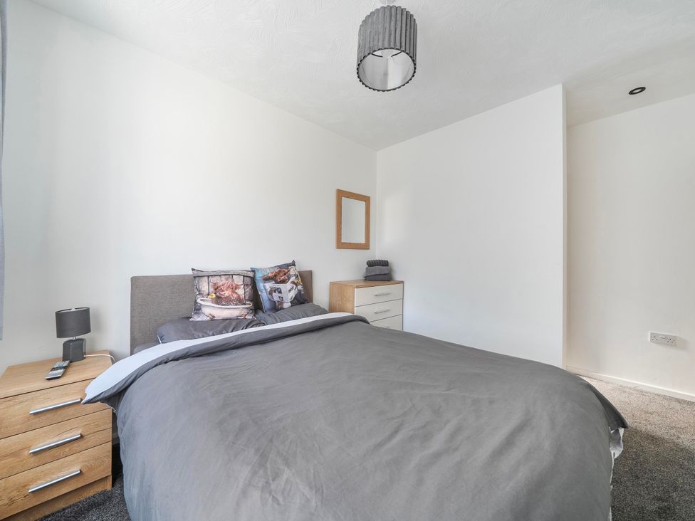 A bedroom with a bed and nightstand at 58 Clifton Rise Abergele