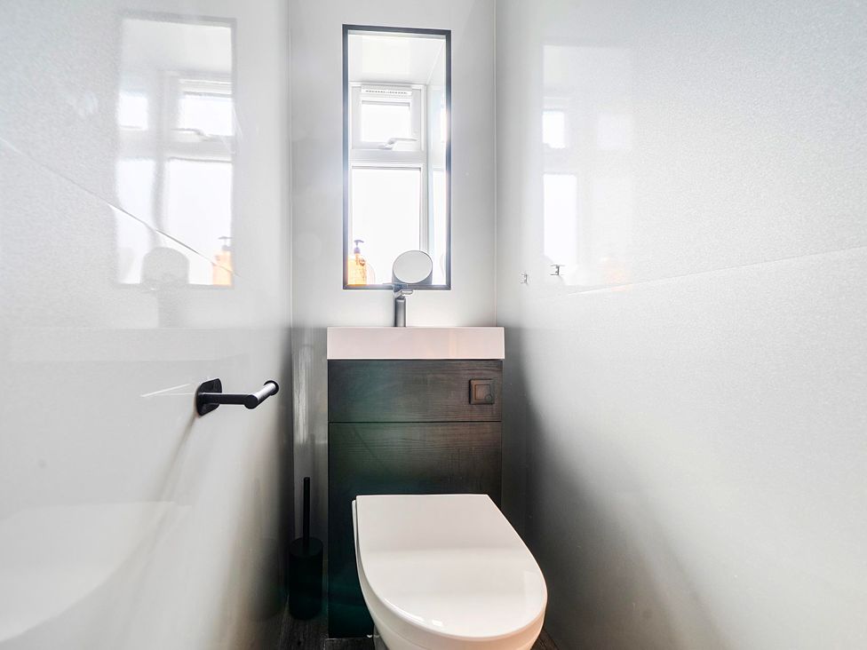 A bathroom with a toilet and sink at 58 Clifton Rise in Abergele