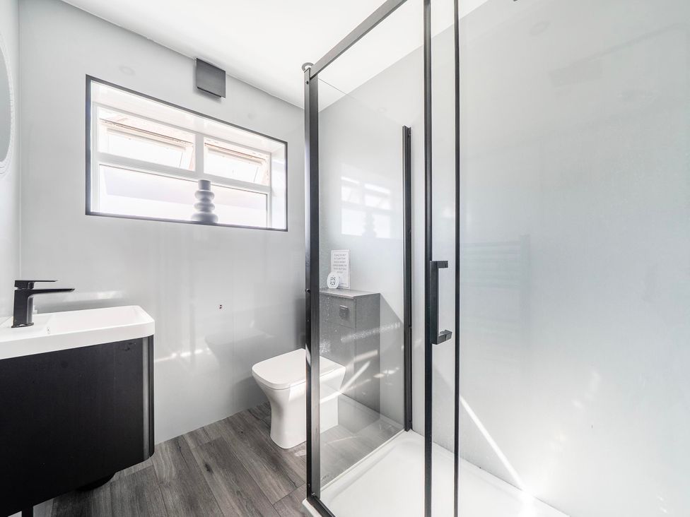 A bathroom with a sink, toilet, and shower at 58 Clifton Rise Abergele
