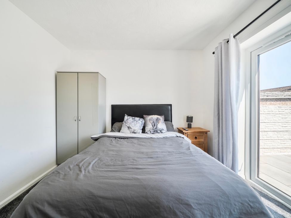 A bedroom with bed and wardrobe at 58 Clifton Rise in Abergele