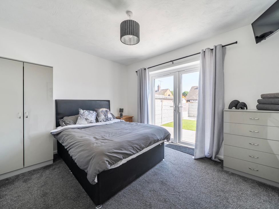 A bedroom with a bed and wardrobe at 58 Clifton Rise in Abergele
