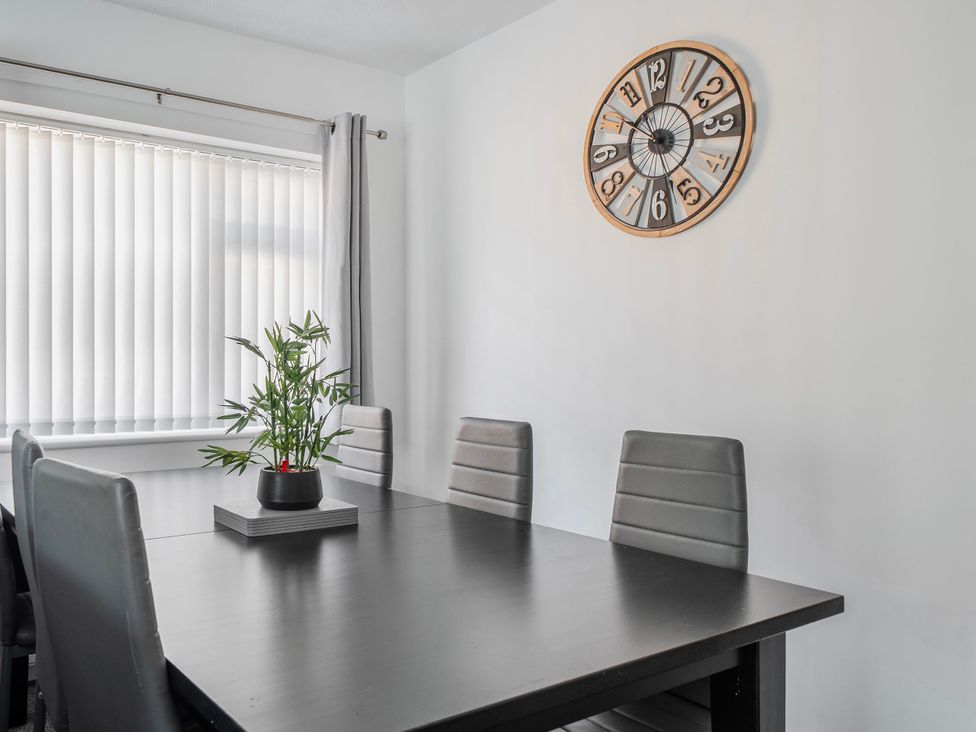 A dining room with a table and chairs at 58 Clifton Rise Abergele