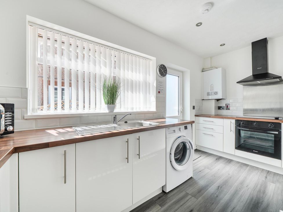 A kitchen with a washing machine and oven at 58 Clifton Rise Abergele