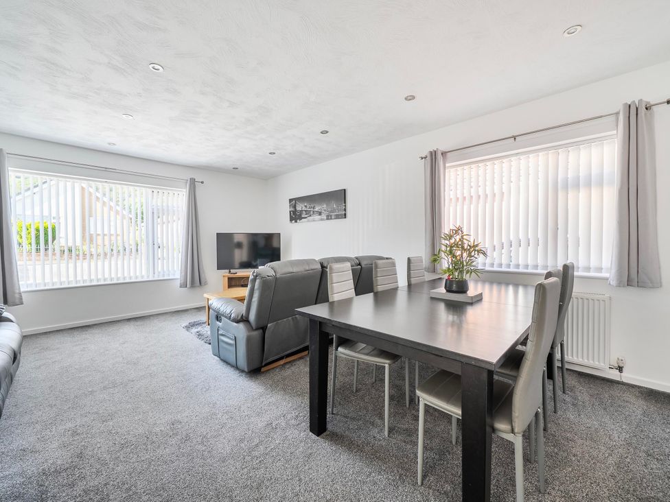 A living room with a dining table and sofa at 58 Clifton Rise Abergele