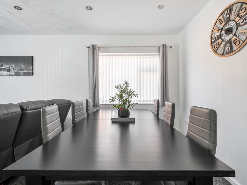 A dining room with a table and chairs at 58 Clifton Rise Abergele