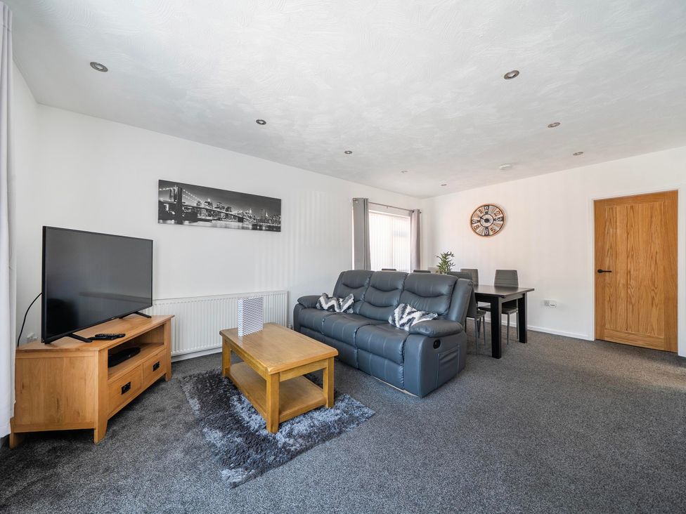 A living room with a sofa and television at 58 Clifton Rise in Abergele