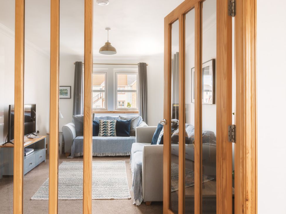 A living room with a sofa and television at Acorn Court
