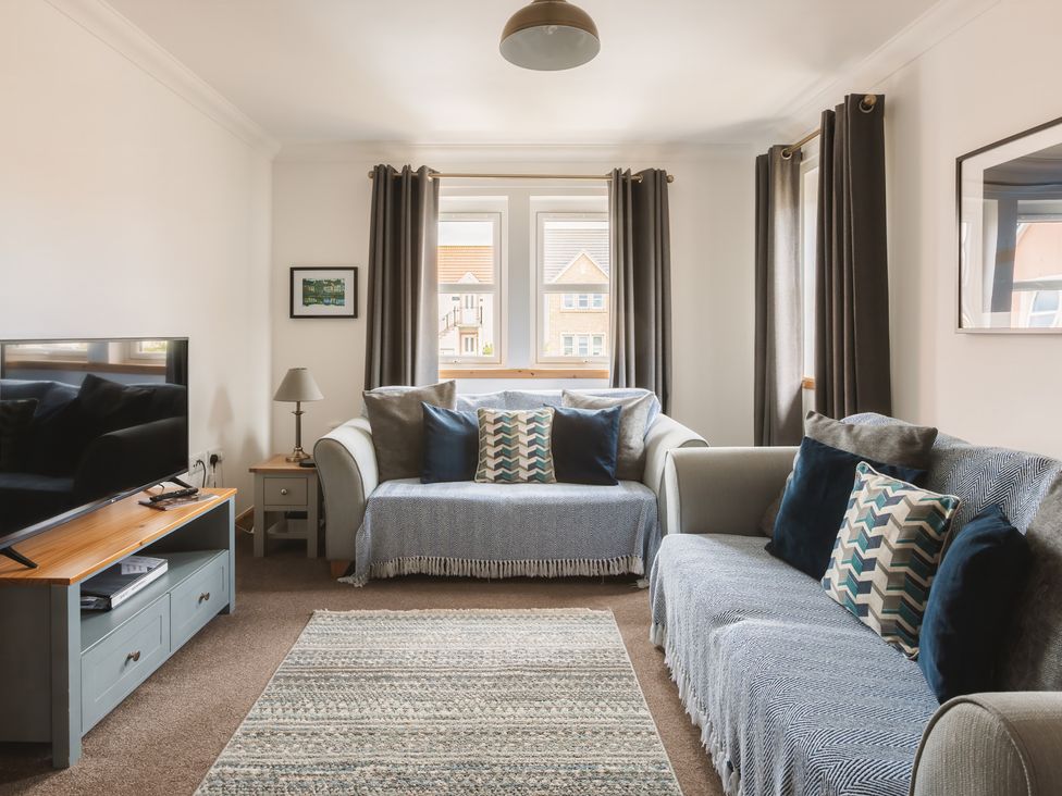 A living room with a sofa and television at Acorn Court