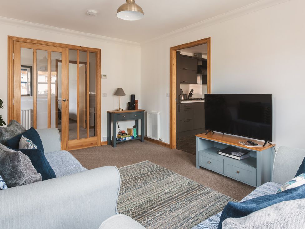 A living room with a television and sofa at Acorn Court 