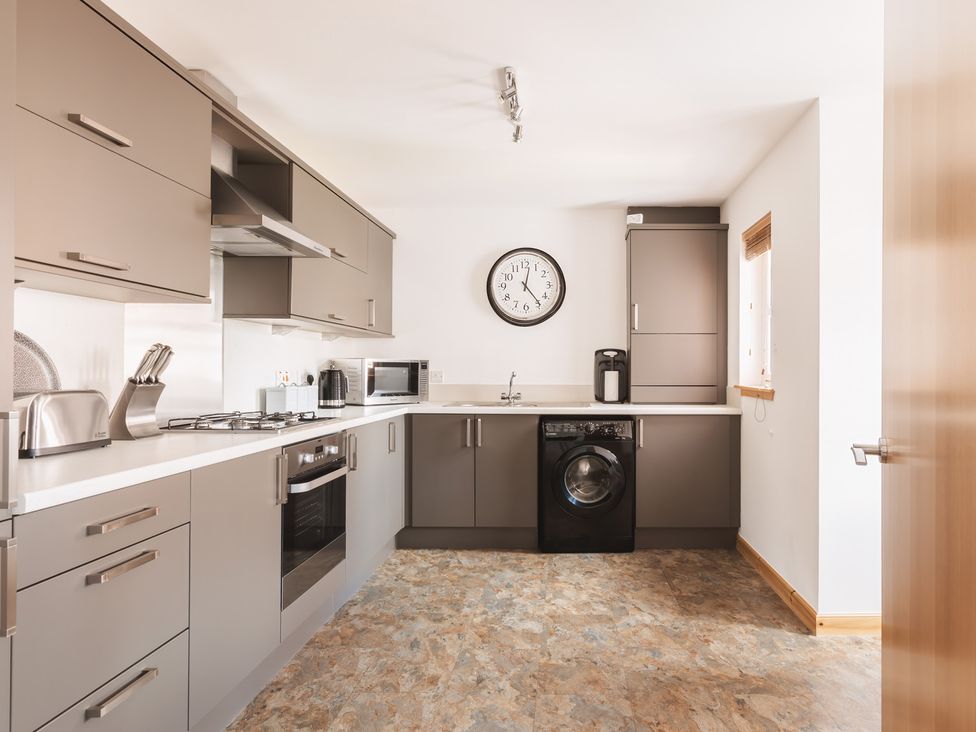 A kitchen with appliances and cabinets at Acorn Court 