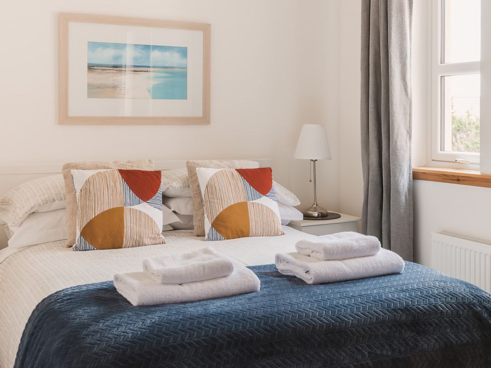 A bedroom with a bed and decorative pillows at Acorn Court 