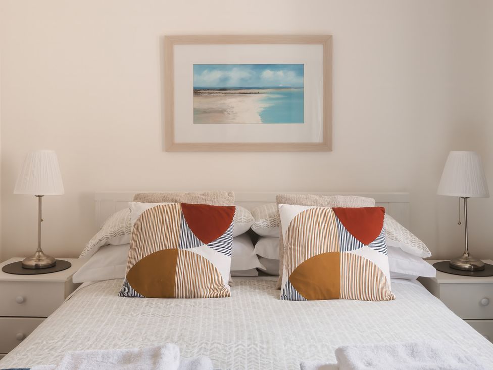 A bedroom with a bed and decorative pillows at Acorn Court