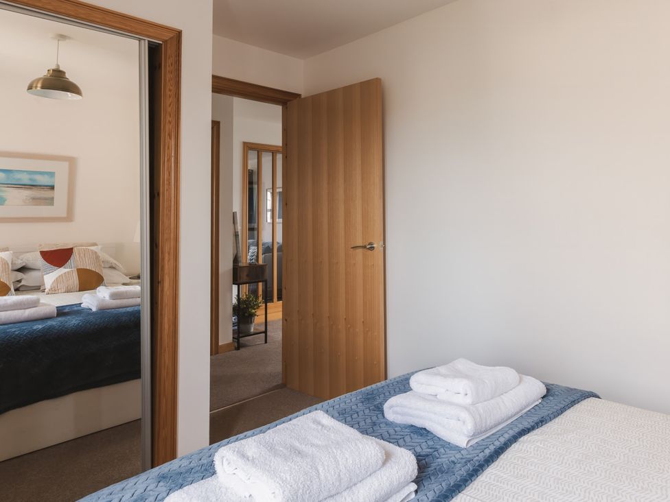 A bedroom with a bed and towels arranged on top at Acorn Court