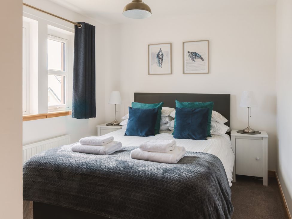 A bedroom with a bed and bedside tables at Acorn Court 