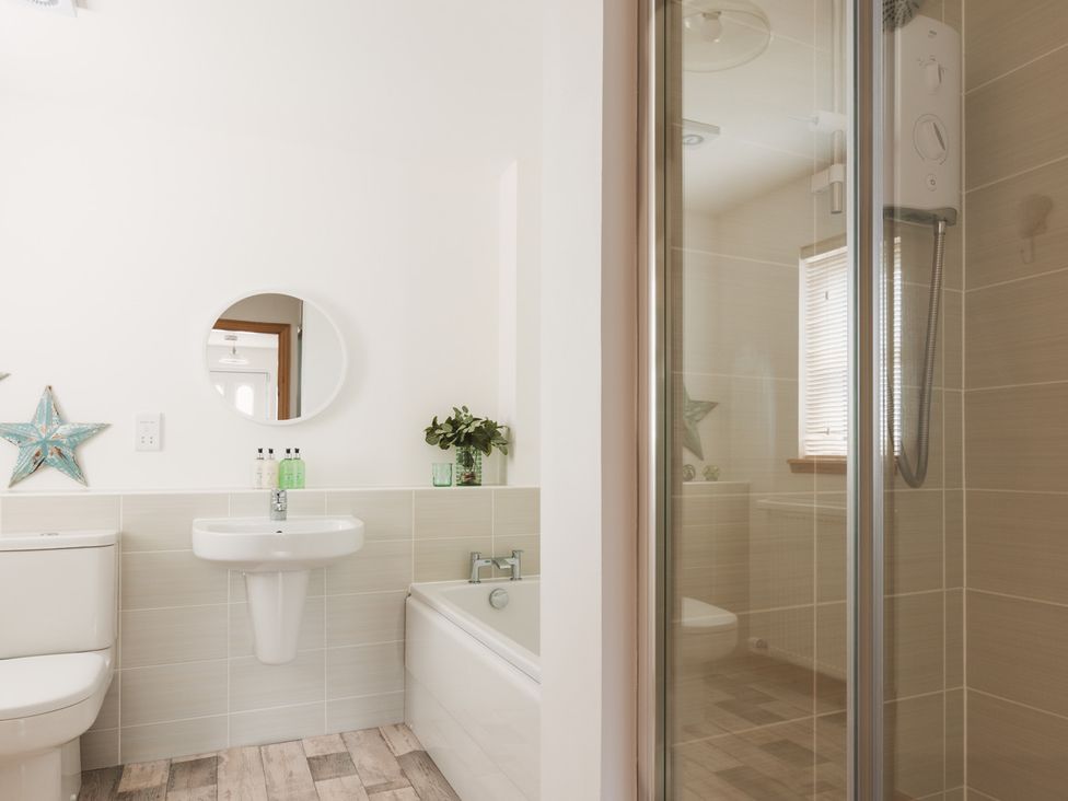 A bathroom with a shower and bathtub at Acorn Court