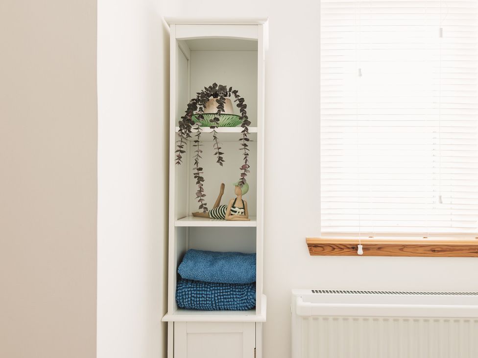 A shelf with towels and decorative items at Acorn Court