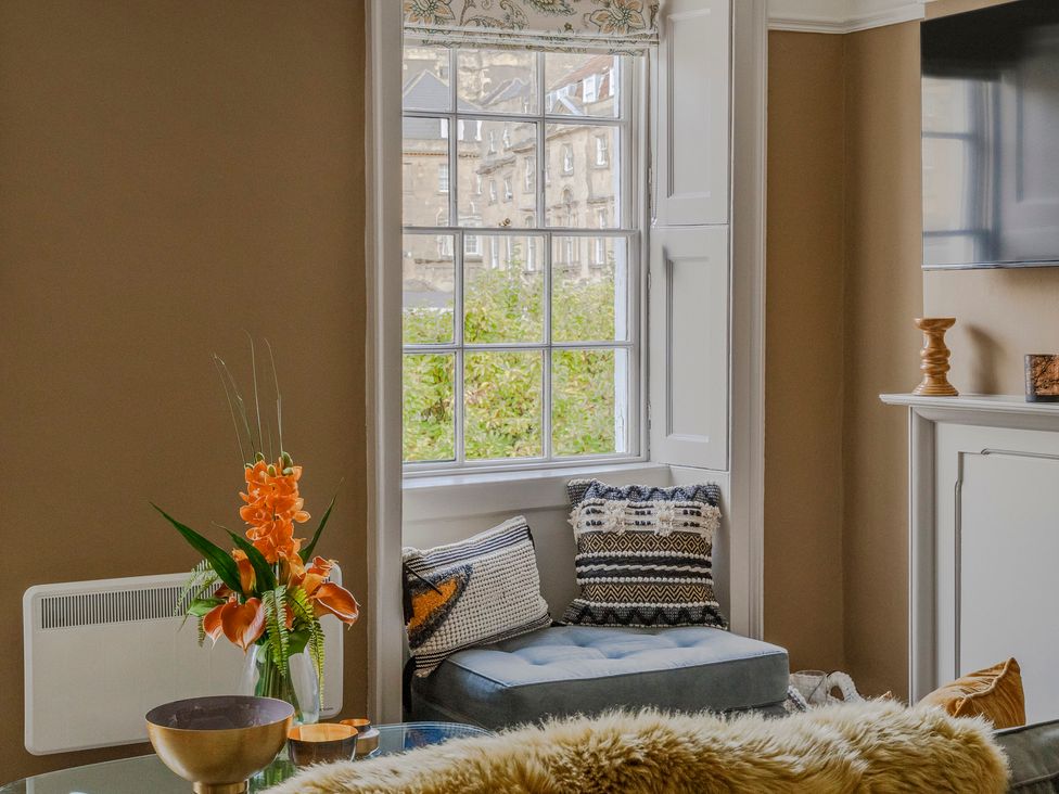 A living room with a flower arrangement and a window at Stay Robun