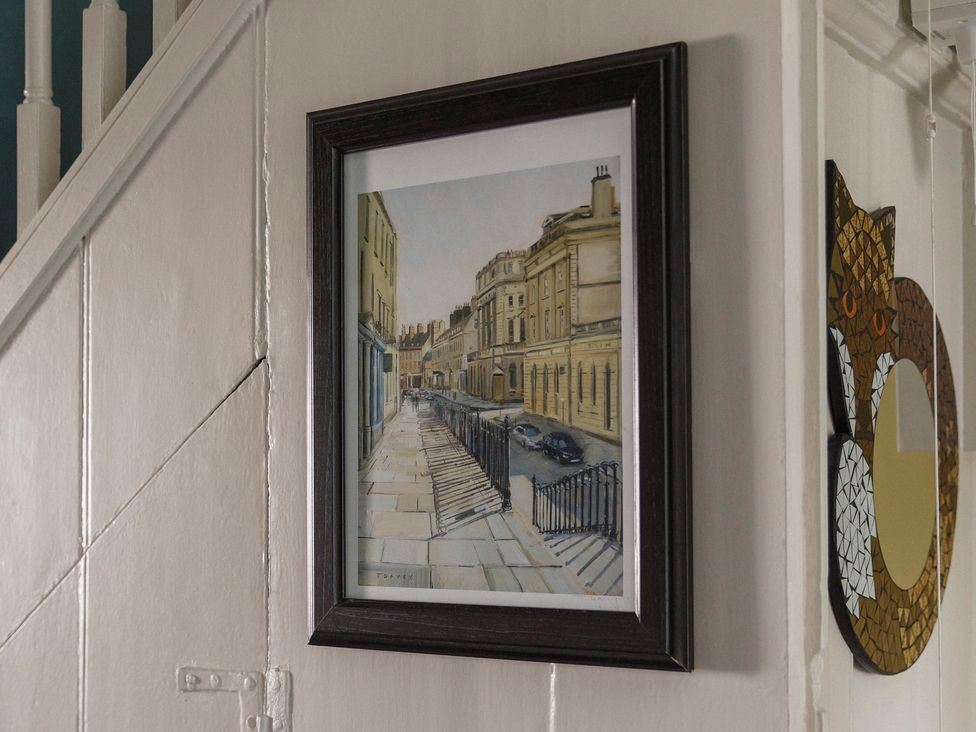 A painting and a decorative mirror on the wall in a hallway at Stay Robun