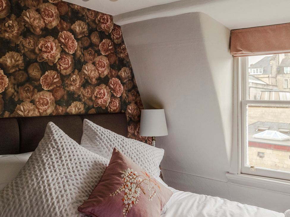 A bedroom with a window and floral wallpaper at Stay Robun