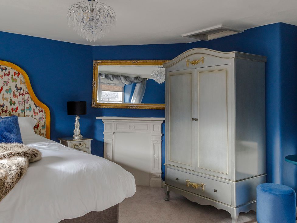 A bedroom with blue walls and a silver wardrobe at Stay Robun
