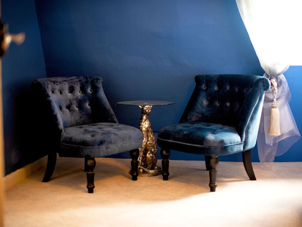 Two blue chairs and a side table in a sitting room at Stay Robun