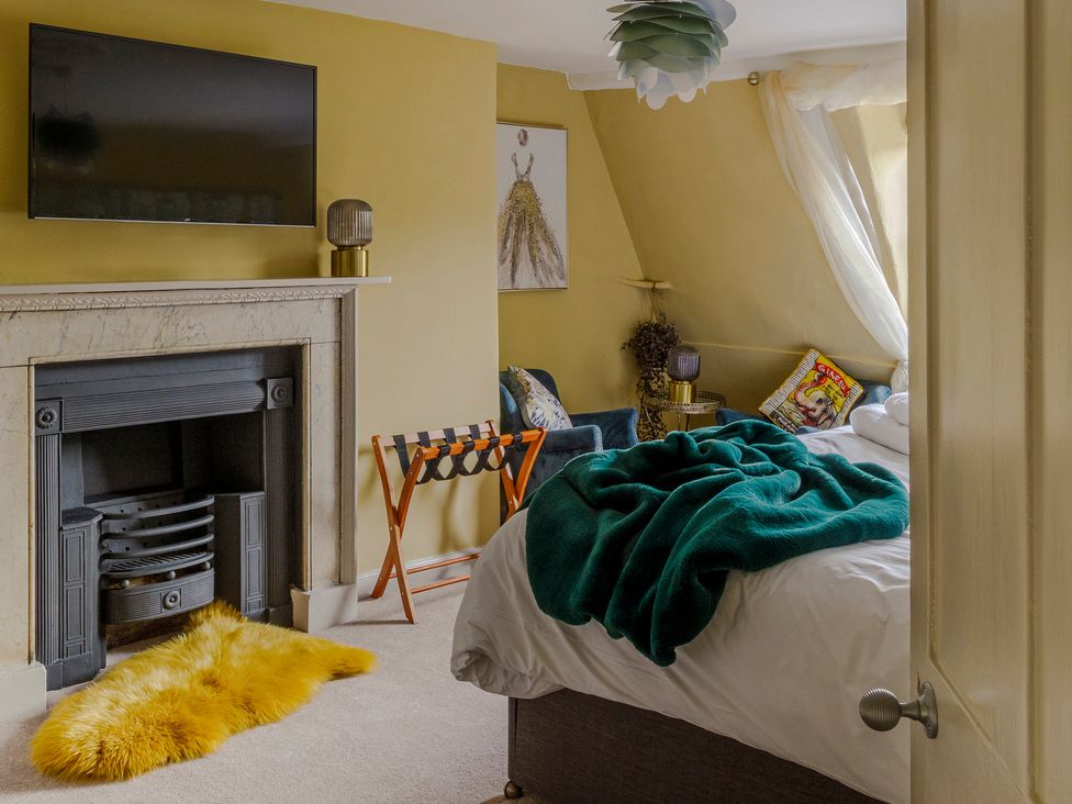 A bedroom with a fireplace, bed, and armchair at Stay Robun