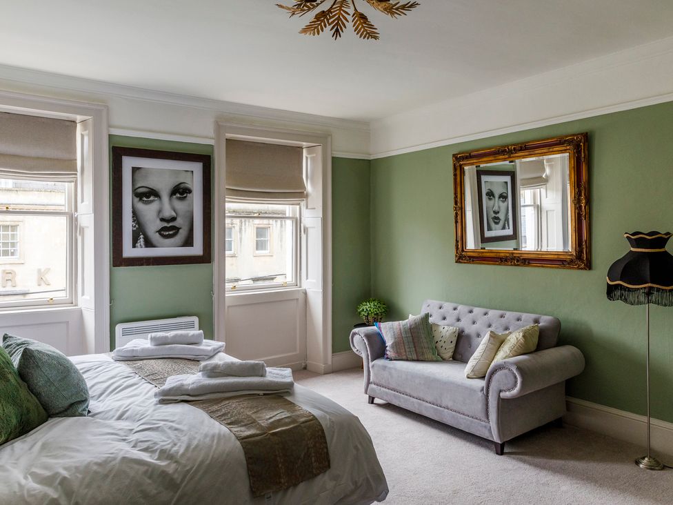 A bedroom featuring a bed and framed photos at Stay Robun