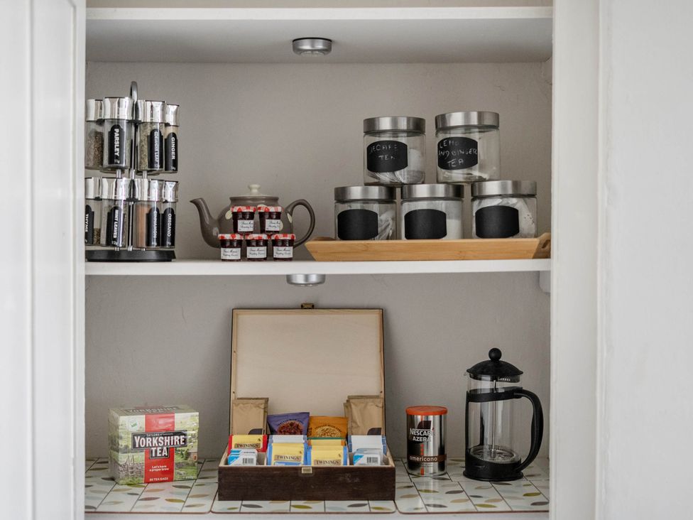 A kitchen shelf with jars, a teapot, and tea at Stay Robun in Bath